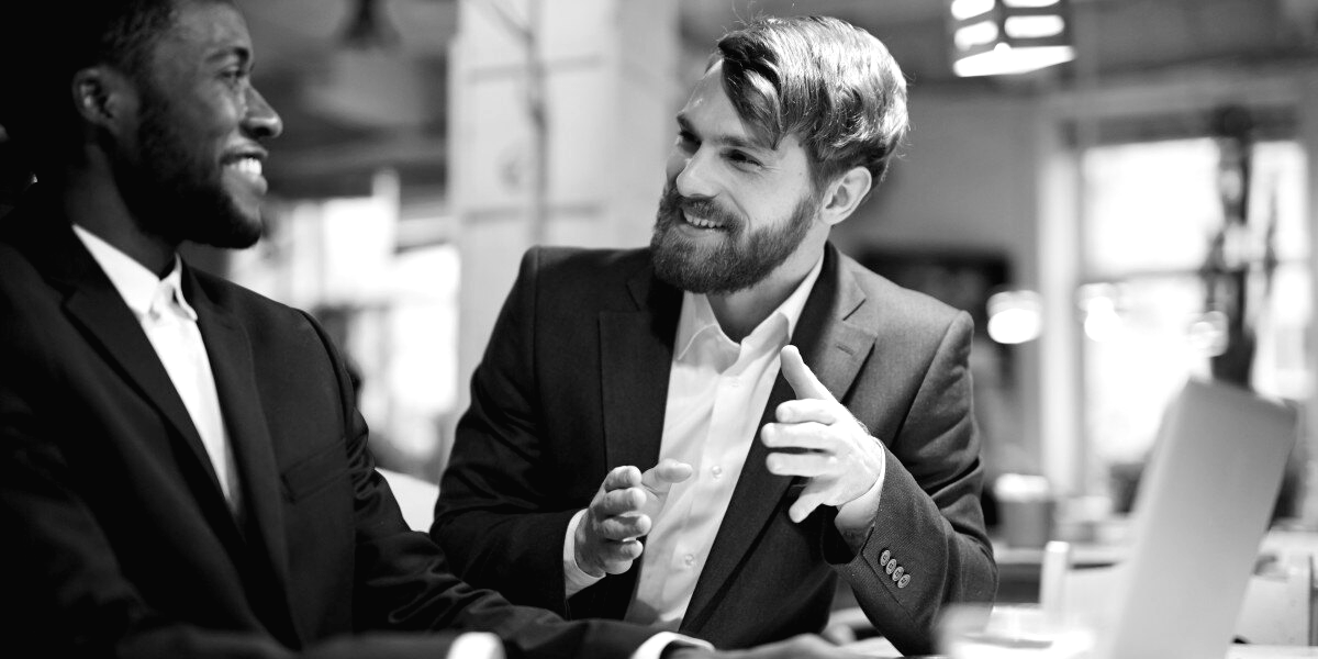 Two commercial reps in conversation over a deal